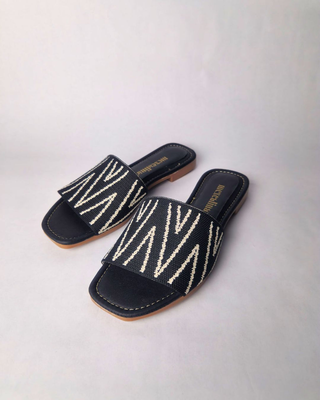 sandalia negra lineas blancas suela marron frontal